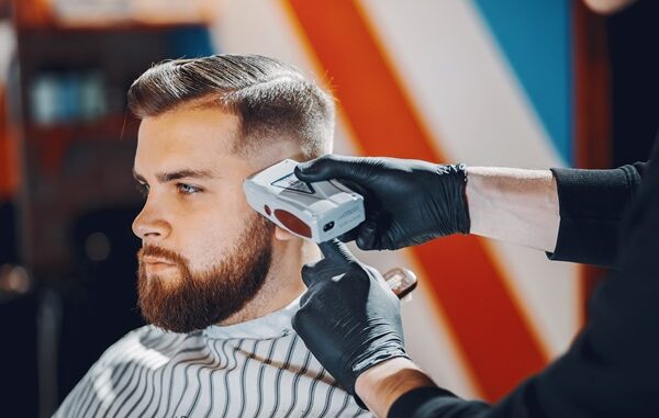 Mejores barberías en CDMX - Barbero usa una máquina de afeitar para cortar el cabello de un hombre
