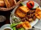 Restaurantes turcos en CDMX - Plato blanco servido con comida tradicional turca y una cesta de pan sobre una mesa de madera