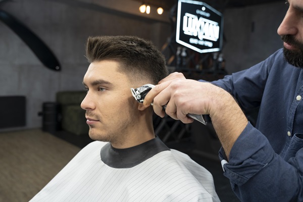 Mejores barberías en CDMX - Barbero usa una máquina de afeitar para cortar el pelo de un hombre