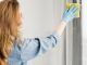 Los 10 mejores servicios de lavado de cortinas en CDMX Mujer remueve el polvo y la suciedad de las ventana y cortinas de una habitación