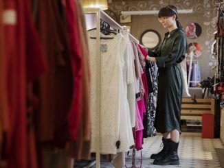 Tiendas de ropa vintage - Joven va de compras por un vestido en una tienda de segunda mano