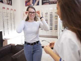 Mejores ópticas en CDMX - Mujer joven probándose diversas monturas de lentes en una óptica