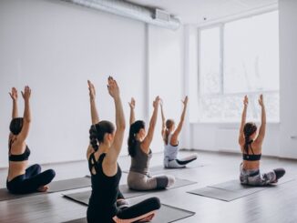 Lugares para practicar yoga en CDMX - Grupo de mujeres hacen una postura de relajación en clases de yoga