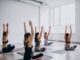 Lugares para practicar yoga en CDMX - Grupo de mujeres hacen una postura de relajación en clases de yoga