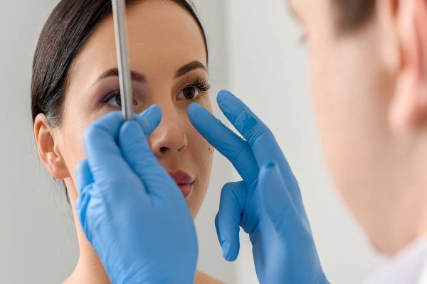 Las 10 mejores clínicas de rinoplastia en CDMX - cirujano plástico revisando la nariz de un paciente