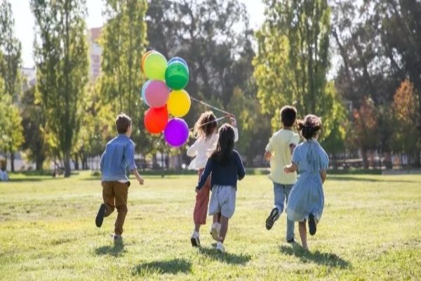 las 10 mejores actividades para niños de preescolar en CDMX - niños corriendo por un parque con un montón de globos