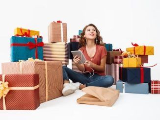 Tiendas de regalo en el centro - Joven rodeada de cajas de regalos termina de hacer las compras de navidad