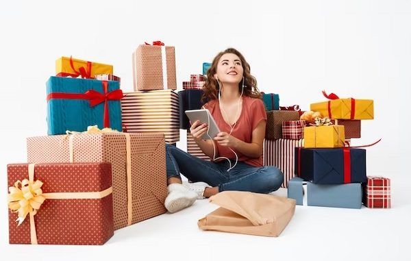 Tiendas de regalo en el centro - Joven rodeada de cajas de regalos termina de hacer las compras de navidad