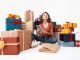 Tiendas de regalo en el centro - Joven rodeada de cajas de regalos termina de hacer las compras de navidad