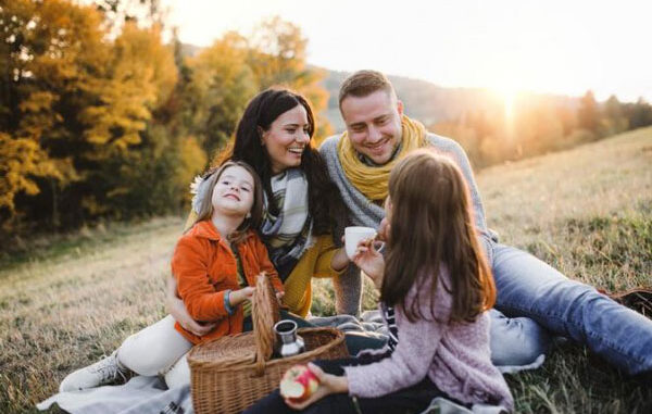 Familia feliz disfruta de un picnic al aire libre para recargar energías