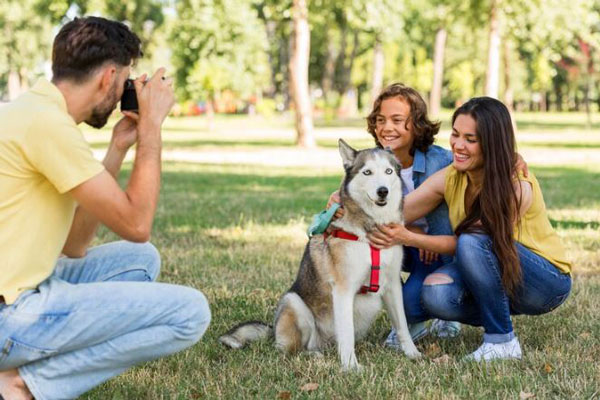 Actividades para año nuevo - Hombre sale a tomarle fotos al perro y a la familia en el parque