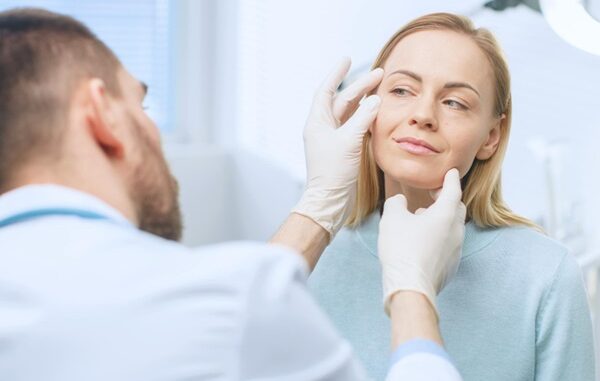 Lifting facial - Médico estético evaluando el rostro de una mujer para realizar un tratamiento de rejuvenecimiento facial