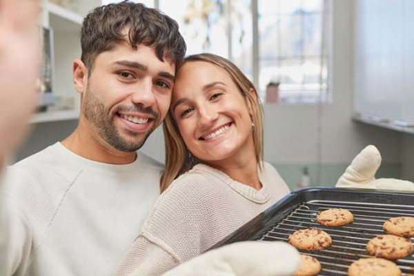 Joven pareja disfruta de hornear galletas juntos los primeros días del año
