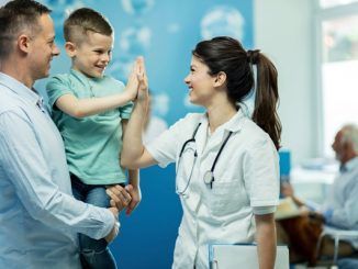 Mejores pediatras CDMX - Doctora choca la mano con un niño sano y feliz después de darle de alta en el hospital