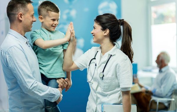 Mejores pediatras CDMX - Doctora choca la mano con un niño sano y feliz después de darle de alta en el hospital