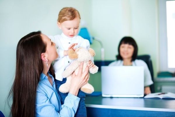 Mujer lleva a su hijo al doctor para darle seguimiento a su proceso de crecimiento y al desarrollo infantil