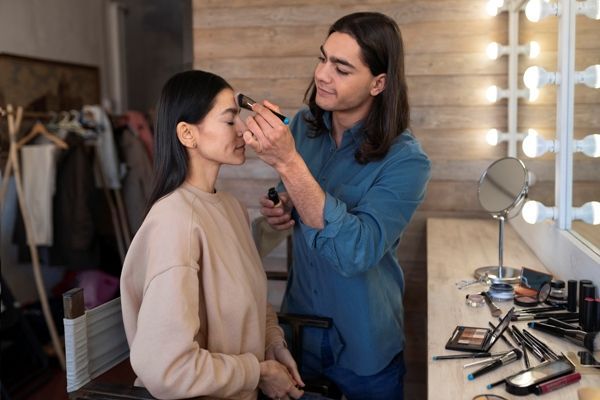 Maquillistas profesionales - Hombre embellece el rostro de una modelo para una sesión de fotos