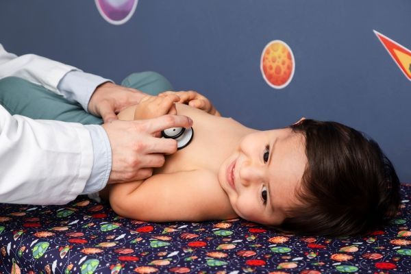 Doctor monitorea la frecuencia cardíaca de un niño en su consultorio