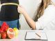 Clínicas de obesidad - Endocrinóloga mide la cintura de una paciente con problemas de sobrepeso
