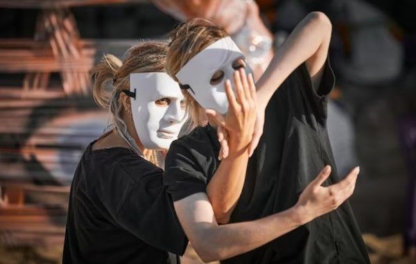 academias de actuación en CDMX - Dos mujeres con máscaras de teatro bailan al compás de la música