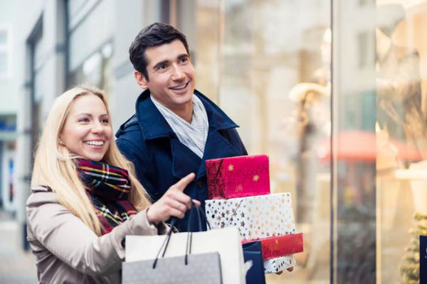 Tiendas de regalo en el centro de CDMX - Pareja feliz viendo vitrinas termina de hacer las compras de los presentes de navidad 