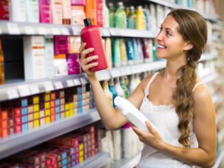 Tiendas de productos para el pelo - Mujer joven escogiendo el mejor champú y acondicionador en una tienda de productos capilares