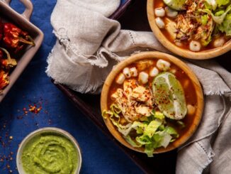 Restaurantes de pozole - Tazón de pozole junto a un recipiente con guacamole y chile, como parte de la comida tradicional mexicana