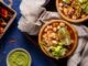 Restaurantes de pozole - Tazón de pozole junto a un recipiente con guacamole y chile, como parte de la comida tradicional mexicana