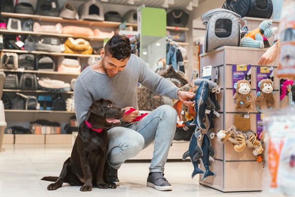Tiendas de juguetes para perros - Hombre escogiendo juguetes de peluche para su mascota en una tienda para perros en CDMX