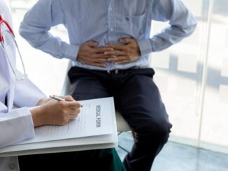 Gastroenterólogos de CDMX - Hombre colocando sus manos en el estómago durante una consulta médica con el gastroenterólogo por problemas digestivos