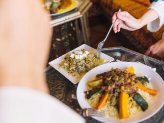 Restaurantes de comida árabe en CDMX - Persona sosteniendo un tenedor para comer un plato árabe tradicional en un restaurante de Ciudad de México
