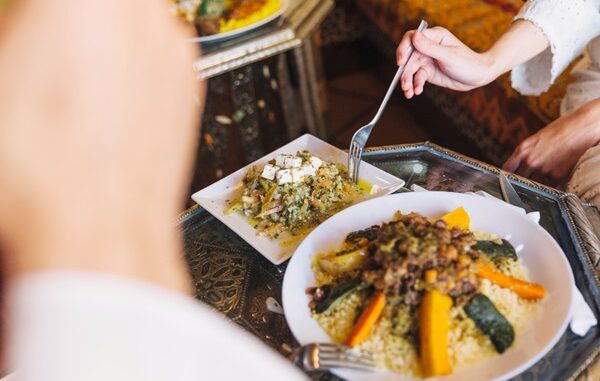 Restaurantes de comida árabe en CDMX - Persona sosteniendo un tenedor para comer un plato árabe tradicional en un restaurante de Ciudad de México