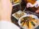 Restaurantes de comida árabe en CDMX - Persona sosteniendo un tenedor para comer un plato árabe tradicional en un restaurante de Ciudad de México