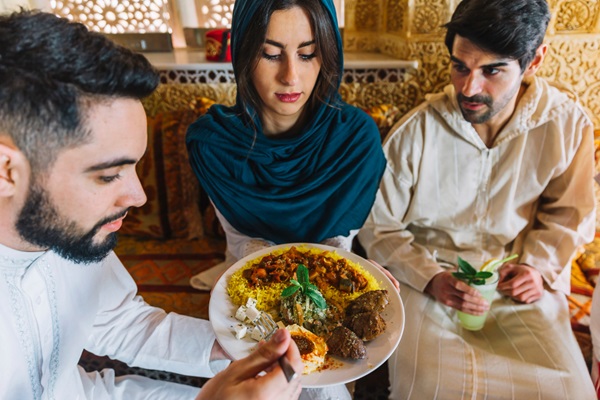 Restaurantes de comida árabe en CDMX - Grupo de personas comiendo en un restaurante árabe un plato tradicional de la cocina libanesa