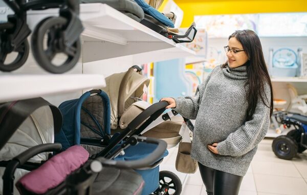 Tiendas de carriolas para bebé - Mujer embarazada observando varios modelos de carriolas en una tienda para bebé en CDMX