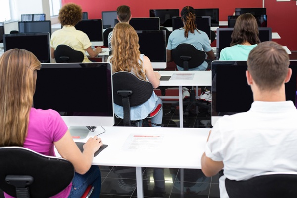 Academias de informática - Grupo de personas en una clase de informática en CDMX usando computadoras modernas para hacer prácticas