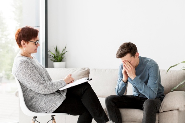 Tratamiento para trastorno de ansiedad generalizado - Hombre en consulta con una psicóloga para aprender a tratar la ansiedad generalizada y problemas de conducta