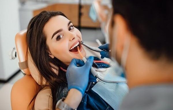 Clínicas dentales en CDMX - Odontólogo realizando una limpieza bucal a una paciente femenina para mejorar la salud de sus dientes
