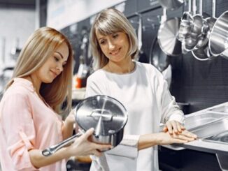 Tiendas de baterías de cocinas baratas - Mujer observando la calidad de una olla de acero inoxidable en una de las mejores tiendas de baterías de cocinas baratas en CDMX