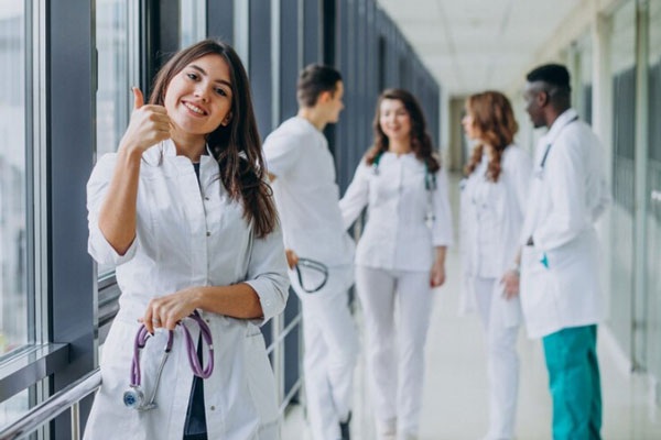 Carreras mejor pagadas - Estudiante de los últimos años de medicina alza el pulgar en señal de optimismo y satisfacción