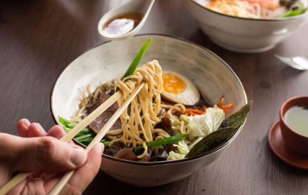 Plano detalle de un ramen asiático con atún, verduras, huevo y fideos