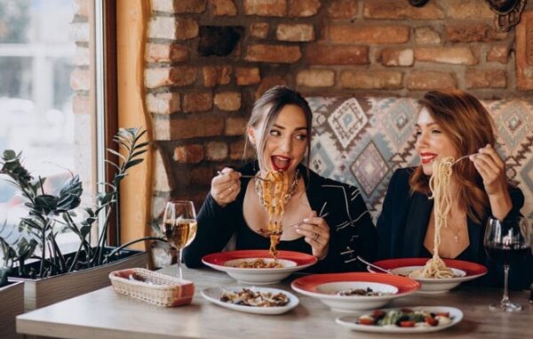 Restaurantes italianos - Mujer comiendo pasta tradicional italiana en uno de los mejores restaurantes italianos en CDMX