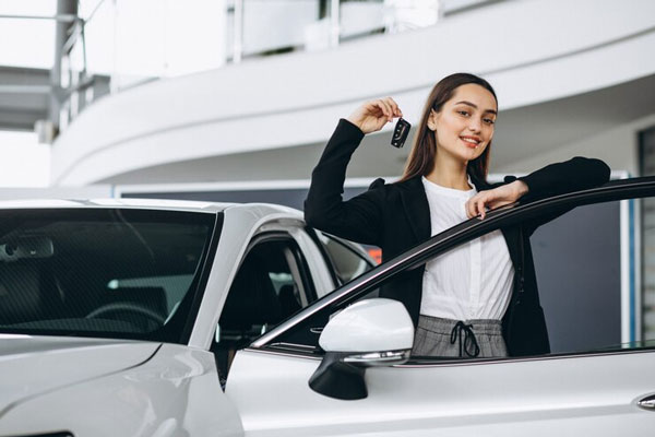 Mujer con control en mano adquiere un nuevo carro en las instalaciones de un concesionario 