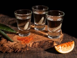 Los 10 mejores mezcales en CDMX - Una tabla exhibiendo tres caballitos o shots de los mejores mezcales de CDMX