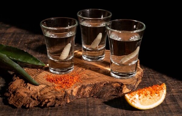 Los 10 mejores mezcales en CDMX - Una tabla exhibiendo tres caballitos o shots de los mejores mezcales de CDMX