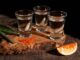 Los 10 mejores mezcales en CDMX - Una tabla exhibiendo tres caballitos o shots de los mejores mezcales de CDMX
