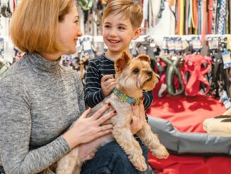 Tiendas para mascotas - Mujer y niño cargando un perro mientras visitan una de las mejores tiendas para mascotas en CDMX