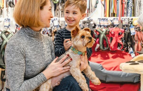 Tiendas para mascotas - Mujer y niño cargando un perro mientras visitan una de las mejores tiendas para mascotas en CDMX