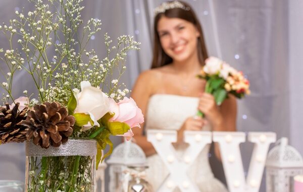 Tiendas para quinceañeras - Mujer joven sonriendo detrás del arreglo para la fiesta de 15 años hecho por una de las mejores tiendas para quinceañeras en CDMX