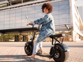 Motos eléctricas CDMX - Mujer de cabello rizado posando sonriente montada en su moto eléctrica en CDMX